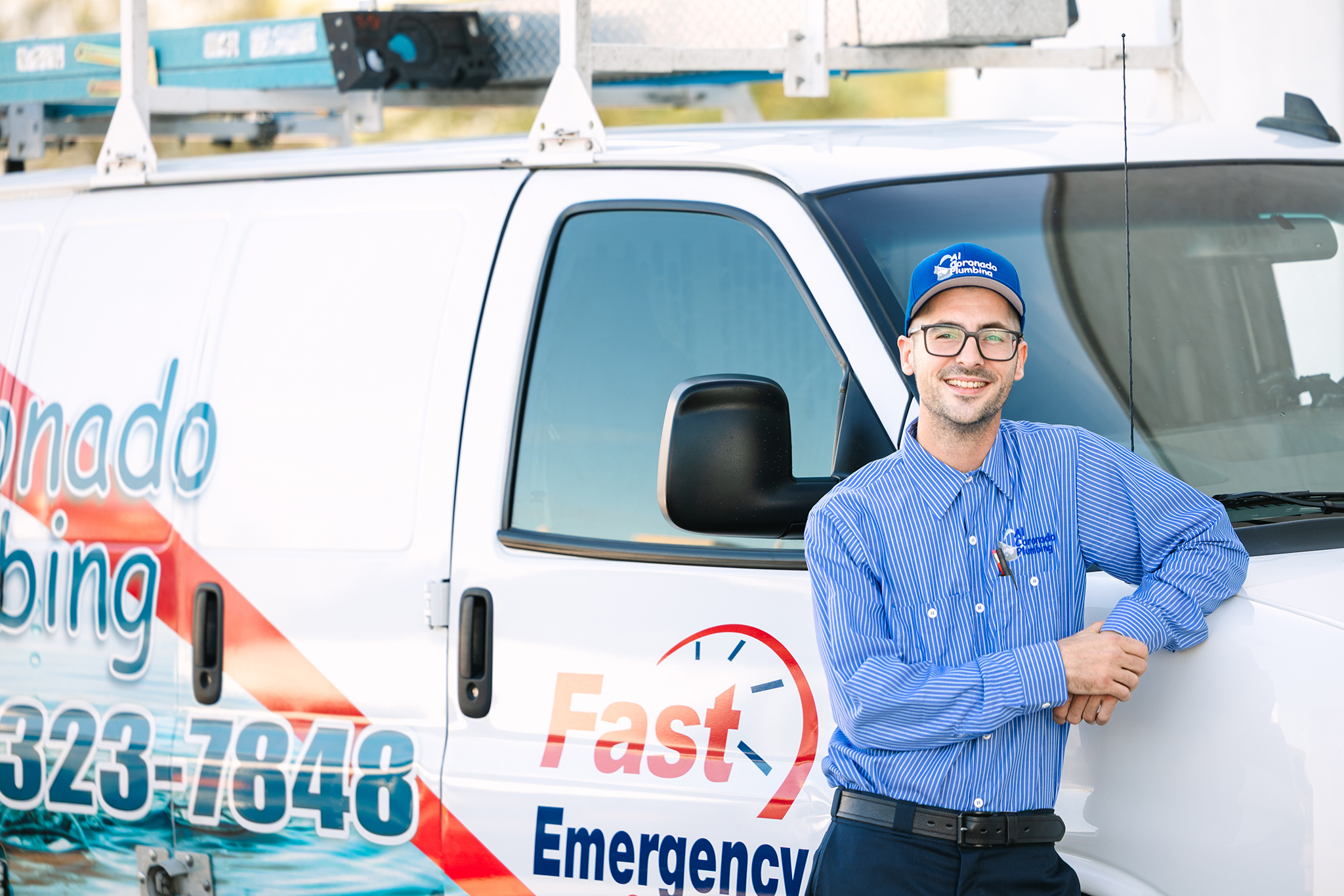 Al Coronado plumbing service technician standing next to a company van
